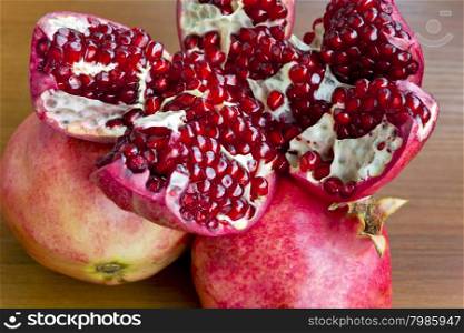 Photo of open pomegranate on brown wooden background