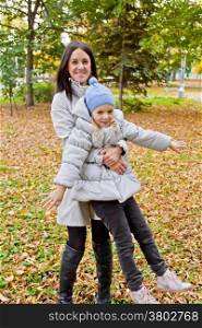 Photo of playing mother and daughter in autumn