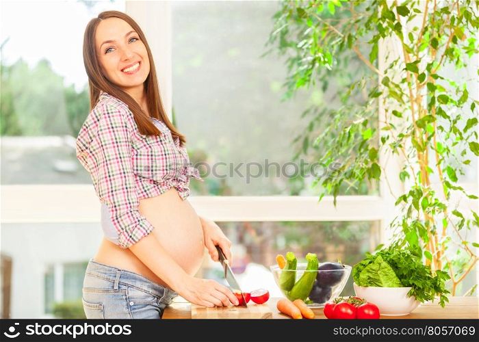 Photo of pregnant woman cooking at home