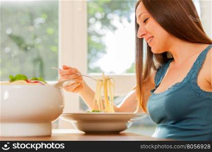 Photo of pregnant woman eating huge portion of pasta with tomato sauce