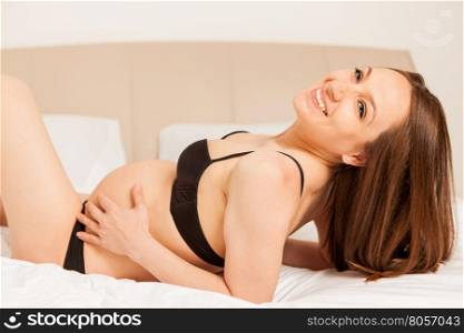 Photo of pregnant woman with lingerie on bed