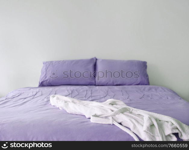 Photo of purple bed with bathrobe