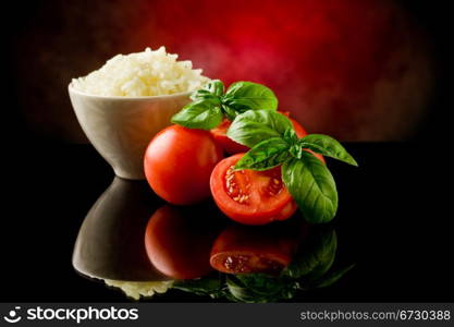 photo of rice inside a bowl with basil and fresh cherry tomatoes