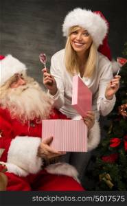 Photo of Santa Claus with his wife surprising and opening Christmas gift at home