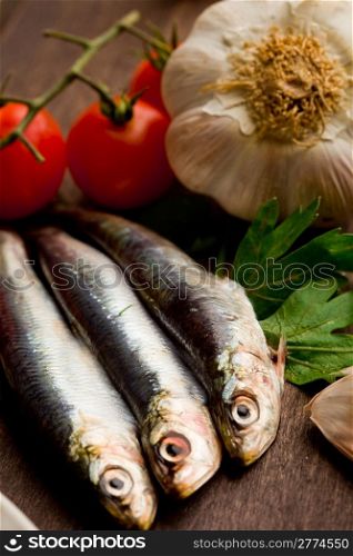 photo of sardines and different ingredients ready to be processed on wooden table