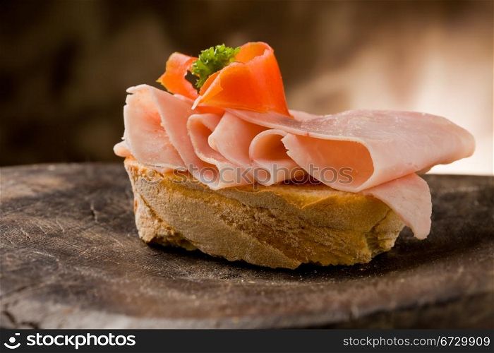 photo of sliced bread with ham and tomato on wooden table
