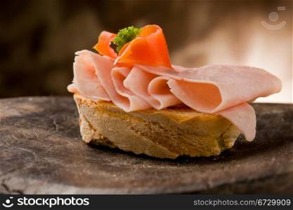 photo of sliced bread with ham and tomato on wooden table