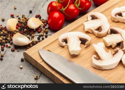 Photo of sliced mushrooms and spices over wooden table