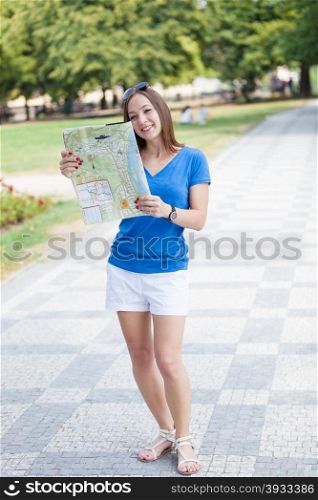 Photo of smiling brunette tourist with a map