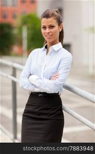 Photo of smiling caucasian businesswoman standing outdoor smiling towards the camera