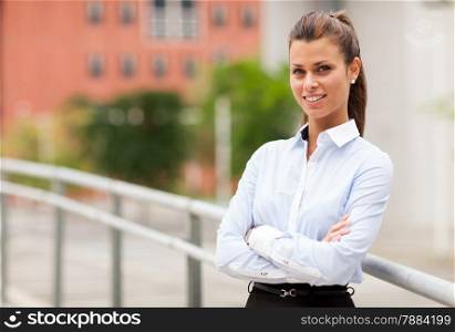 Photo of smiling caucasian businesswoman standing outdoor smiling towards the camera