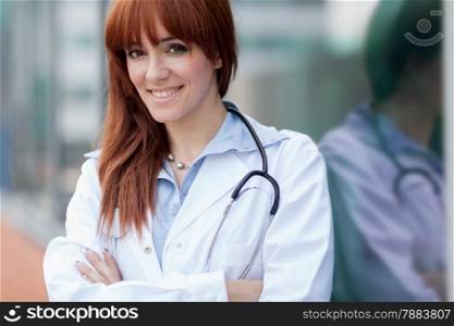 photo of smiling caucasian female doctor standing next to window