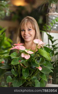 photo of smiling caucasian woman choosing a plant in a flower shop