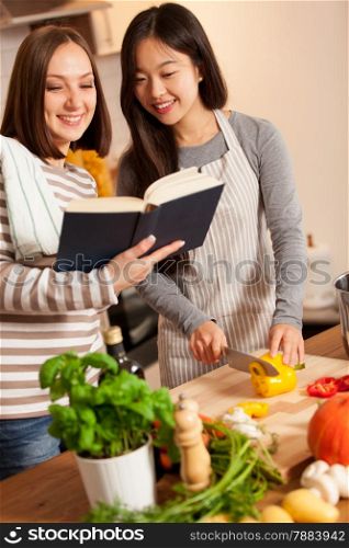 photo of smiling female friends cooking in the kitchen at home