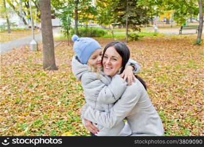 Photo of smiling mother and daughter in autumn