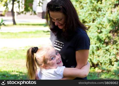 Photo of smiling playing mother and daughter