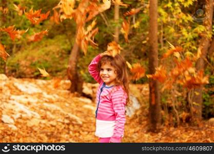 Photo of sweet little girl in autumn forest, adorable child playing game in fall park, pretty kid enjoying autumnal nature, beautiful golden trees foliage, nice warm sunny day&#xA;