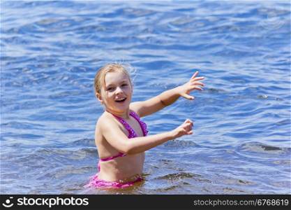 Photo of swimming cute girl in pink swimsuit