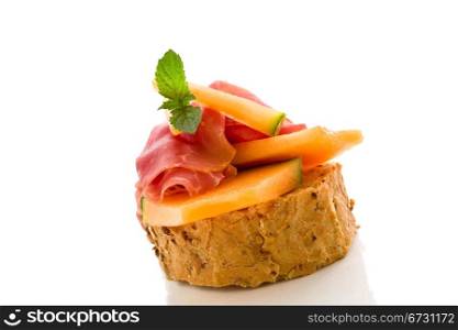 photo of tasty bread slices with bacon and melon on isolated background
