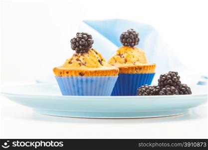 Photo of tasty muffins with blackberries over white isolated background