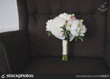 Photo of the bouquet on the big chair.. A bouquet of flowers on a brown chair 6734.
