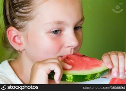 Photo of the cute girl eating watermelon