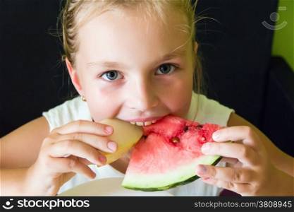 Photo of the cute girl eating watermelon and melon