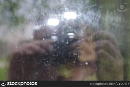 Photo of the photographer blurred focus on the dried droplets of glass, green nature background
