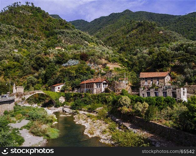 Photo of the stone bridge and river in the small old town of Badalucco in Italy in the province of Imperia, the Italian region Liguria.