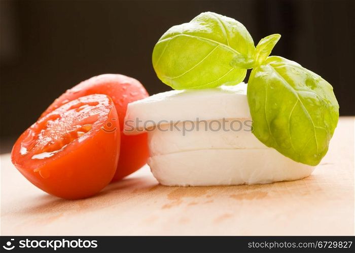 photo of tomatoe and mozzarella on wooden cutting board
