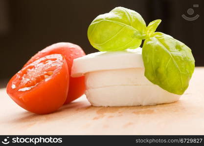photo of tomatoe and mozzarella on wooden cutting board