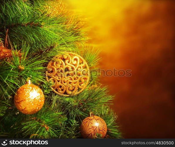 Photo of traditional Christmas tree isolated on brown grunge background, green fir decorated with golden bubbles toy, happy New Year greeting card, adorned pine tree at home, winter holidays