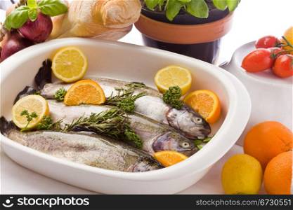 photo of trout preparation with orange and lemon in white bowl