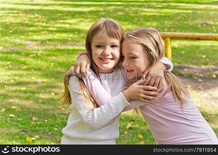 Photo of two embracing girls in summer