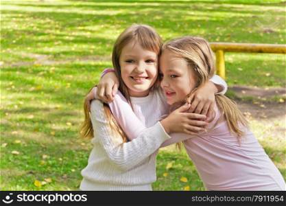 Photo of two embracing girls in summer