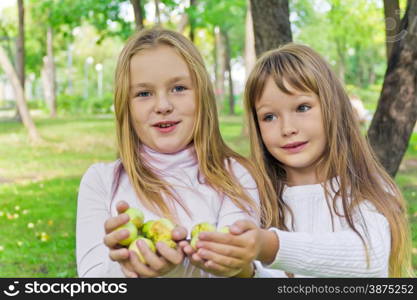 Photo of two girls with apples in summer