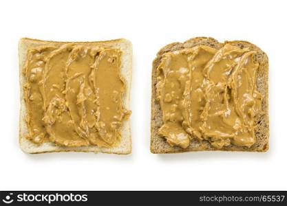 Photo of two slices of white and whole wheat bread covered in peanut butter, isolated on white.