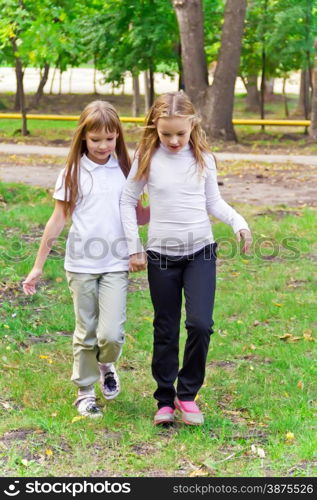 Photo of two walking girls in summer