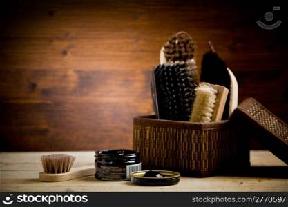 photo of various brushes on wooden table used for polishing shoes