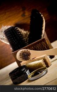 photo of various brushes on wooden table used for polishing shoes