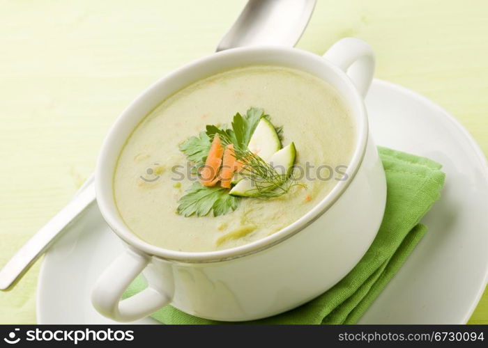 photo of vegetarian vegetable soup on green wooden table with different vegetables arround