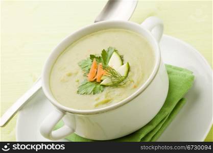 photo of vegetarian vegetable soup on green wooden table with different vegetables arround