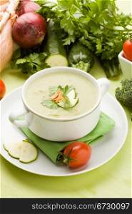 photo of vegetarian vegetable soup on green wooden table with different vegetables arround