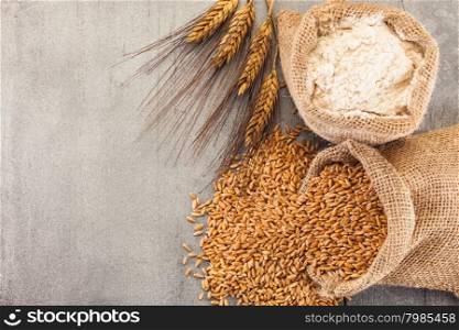 Photo of wheat grains and flour on the wooden table