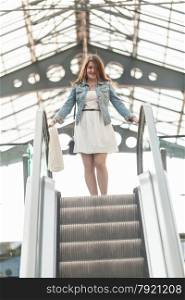 Photo of woman standing on top of escalator at shopping mall