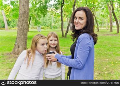 Photo of woman with two girls drinking tea