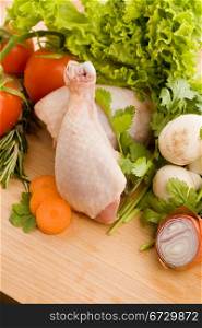 photo of wooden chopping board with chicken and vegetables