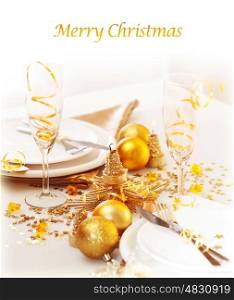 Photo of xmas holiday table setting, closeup festive dinnerware still life, two glasses for champagne, traditional New Year alcohol beverage, luxury white plate decorated with golden bubble toy