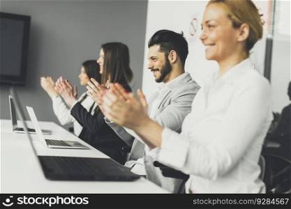 Photo of young business people applauding at conference