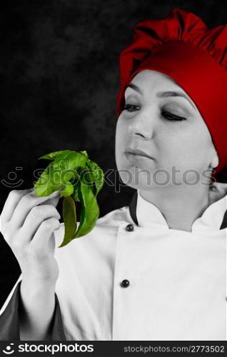 photo of young female chef controlling basil quality